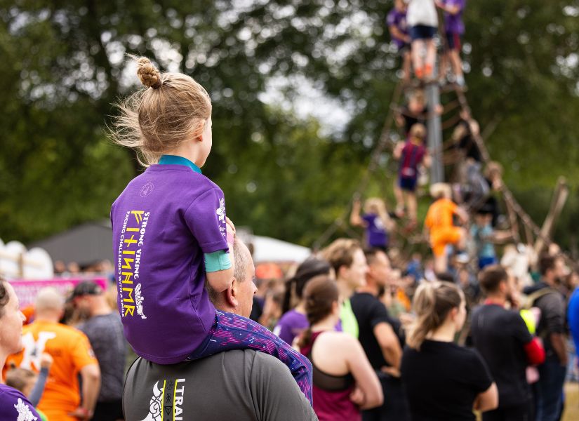 meisje dat op de schouders zit van haar vader