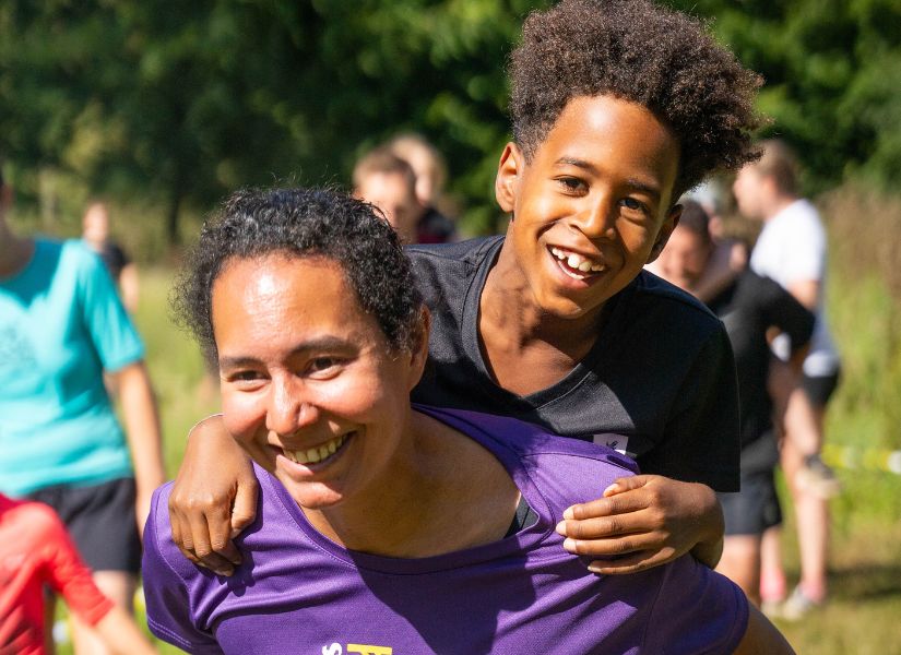 kindje op de rug van de moeder tijdens de family run van strong viking