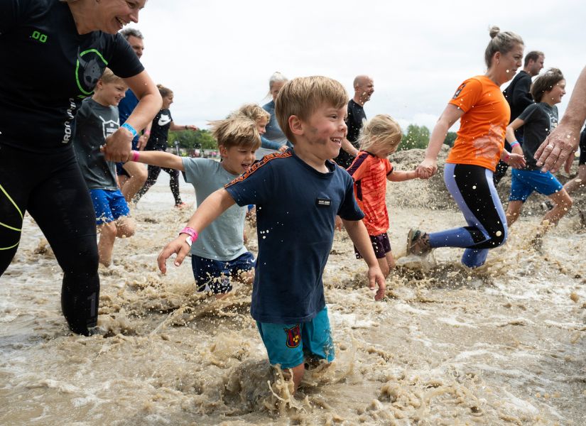 kindjes die door het water rennen met hun ouders tijdens de family run van strong viking