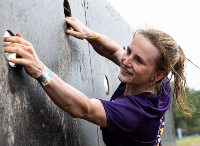 vrouw die aan obstakel klimt