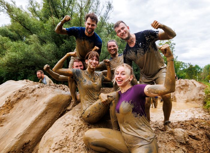 A group of friends covered in mud.