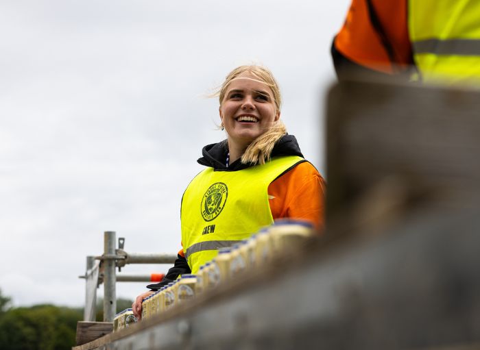 crew member die lachend alcoholvrije biertjes uitdeelt
