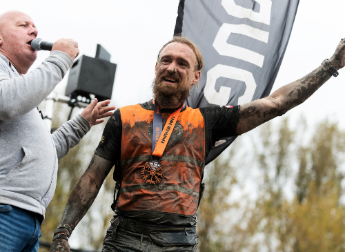 een ultra viking deelnemer die onder de modder zit